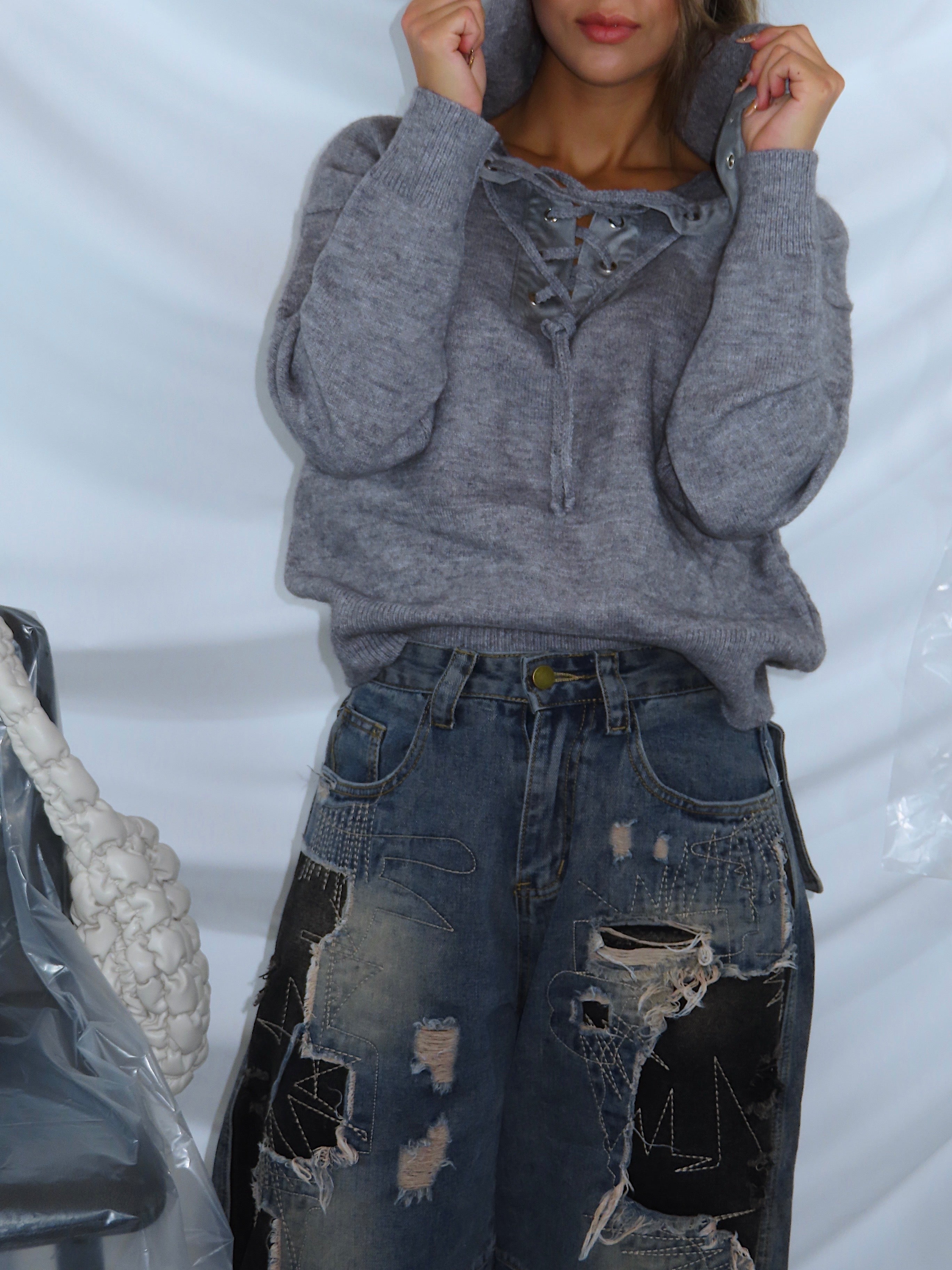 Primo piano del maglione da donna grigio, indossato da modella.