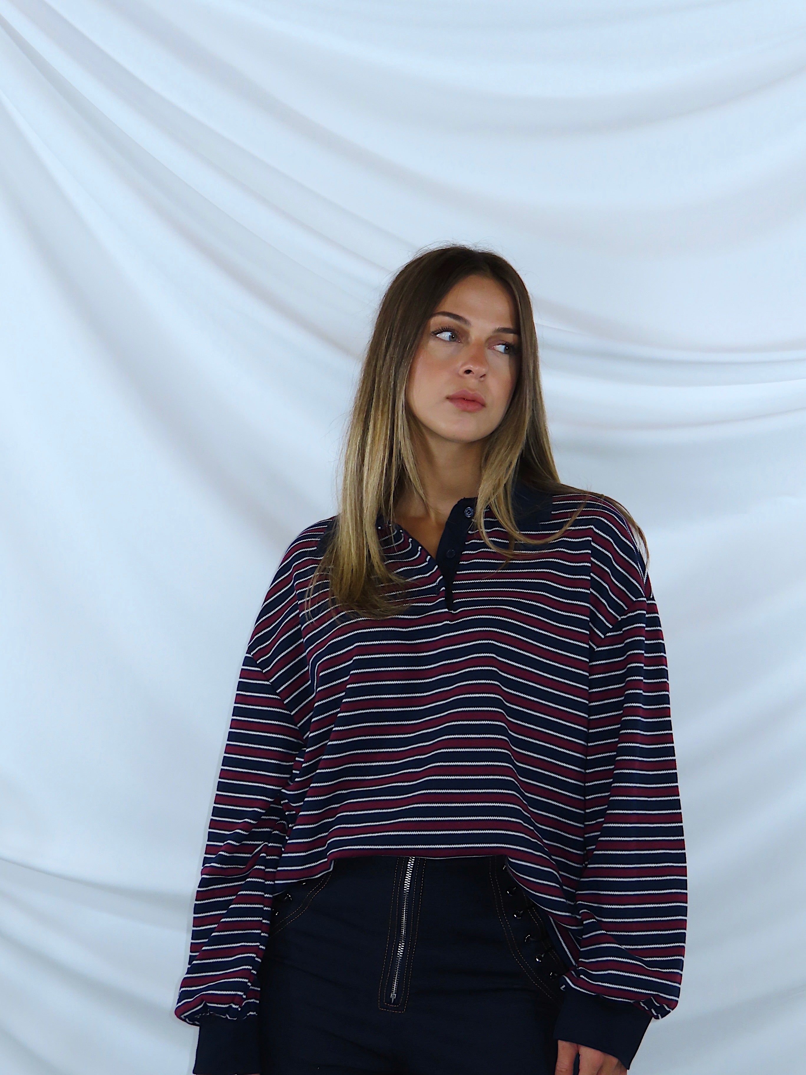 Polo a righe bordeaux e blu, primo piano frontale, colletto a polo e bottoni, ideale per look casual.