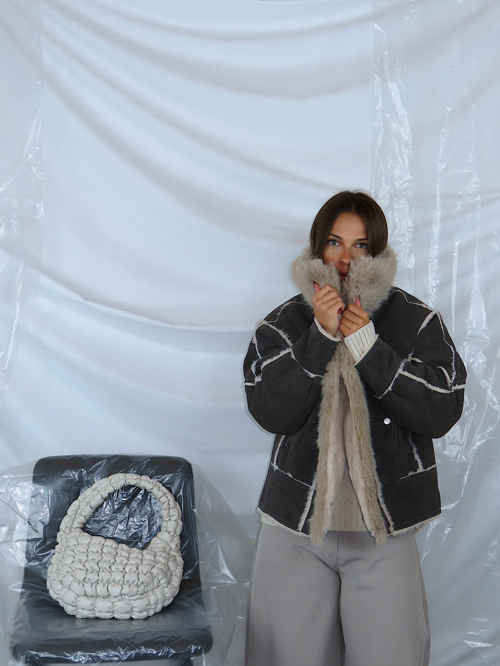 Dettaglio ravvicinato di giacca aviatore con colletto imbottito e interno in eco pelliccia.