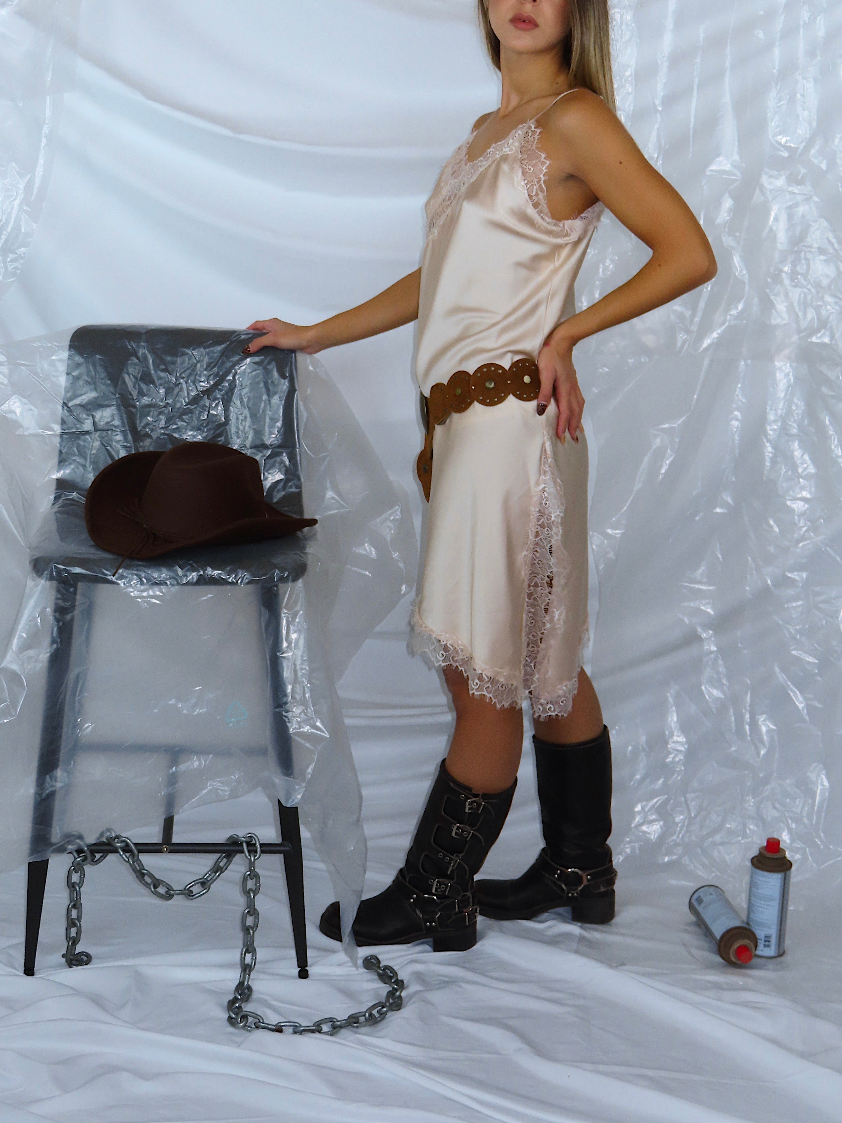 Vista laterale con focus sui dettagli in pizzo dell'abito asimmetrico, indossato da modella.