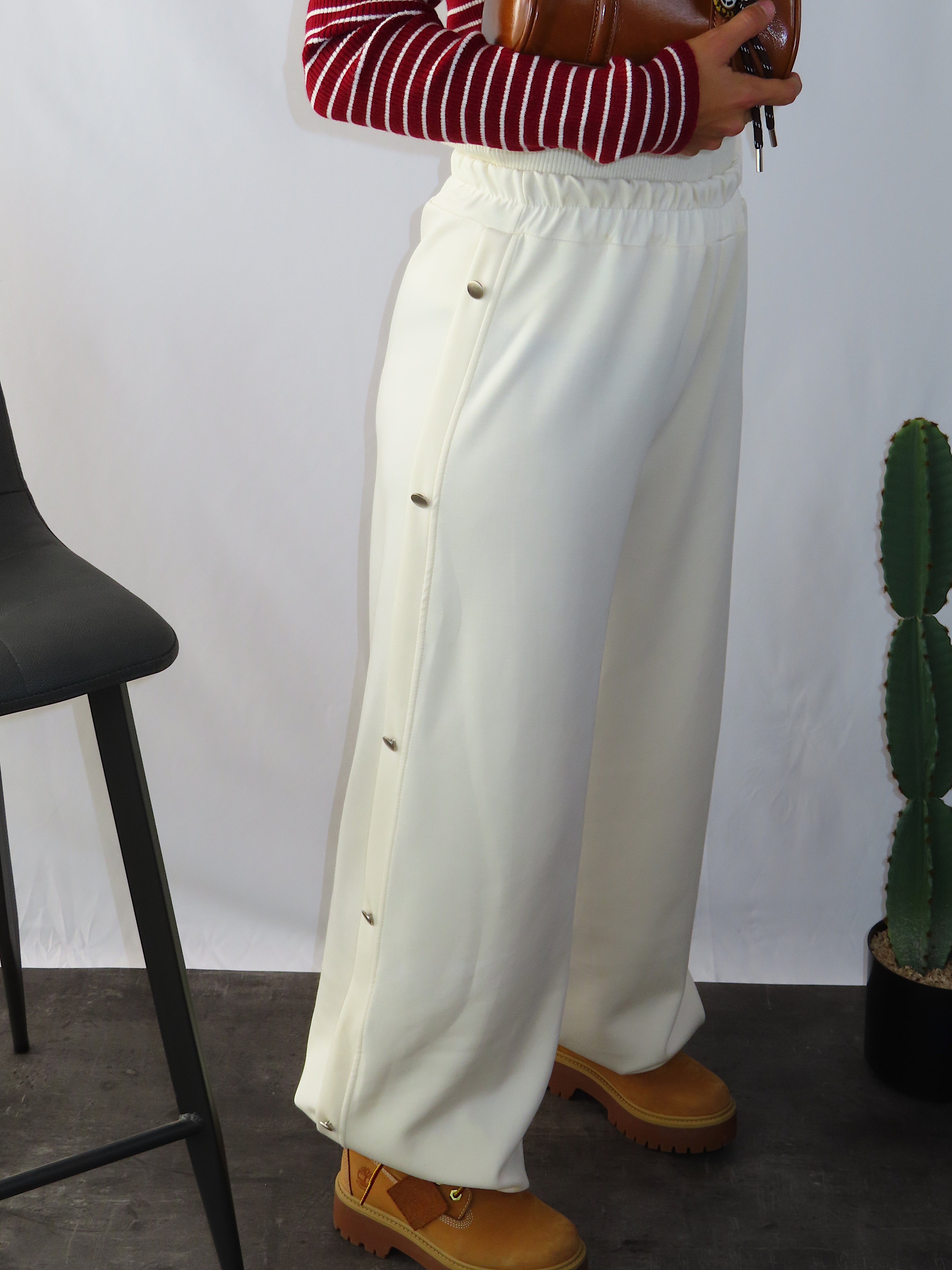 Vista laterale dei pantaloni tuta larghi Pants Cozy color panna con bottoni sul fianco