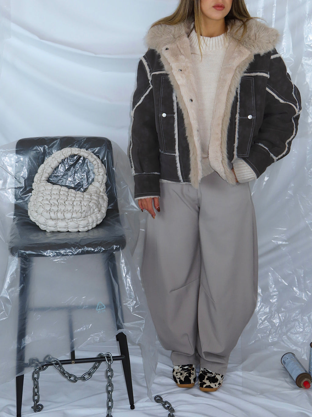 Vista ravvicinata di outfit completo con giacca aviatore e pantaloni balloon grigi, look casual urbano e moderno.